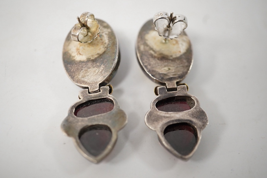 A pair of modern yellow and white metal mounted three stone oval cabochon garnet set drop earrings, by Elaine Coyne, signed, 51mm, gross weight 28.2 grams. Condition - fair